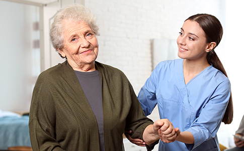 Hospice Nurse With Certification Helping An Elderly Lady Walk